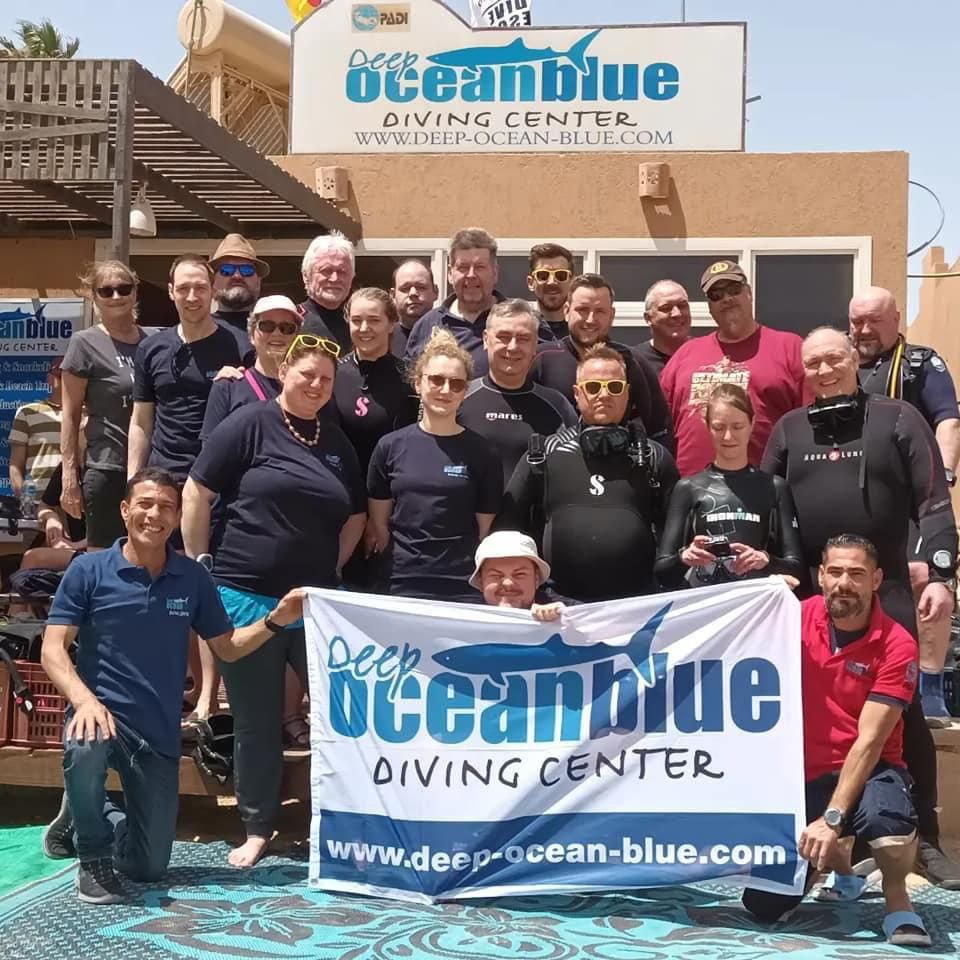Gruppenfoto der Fahrt nach Ägypten 2023, Banner von Deep Oceal Blue Diving Center im Vordergrund